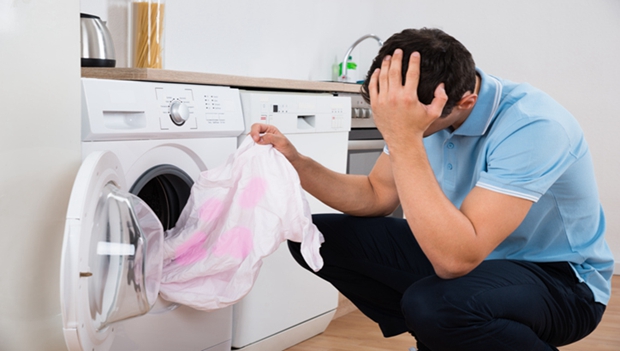 Tensed Man Holding Dirty Tshirt By Washing Machine